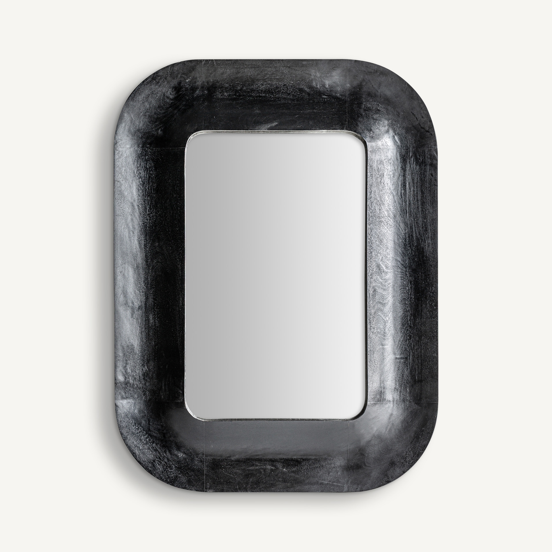Rectangular mirror with rounded corners and a sculptural black wooden frame
